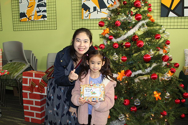 Mother and child sitting next to a decorated Christmas tree