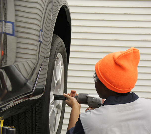 Black Student working on a car