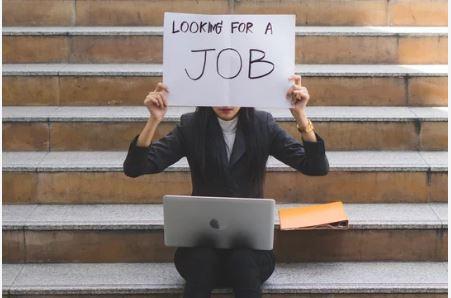 Business woman holding a looking for a job sign