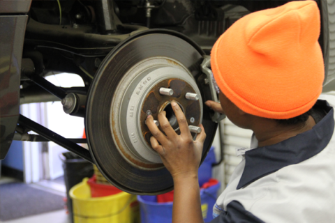 Black Student working on a car