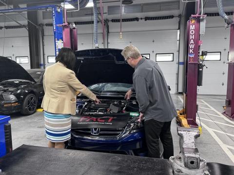 2 peple looking at the engine of a Honda Car