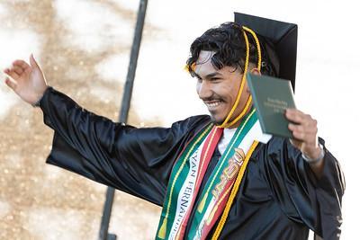 Male student at graduation holding a certificate