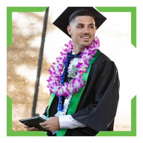 Graduatiing student smiling, holding the graduation program